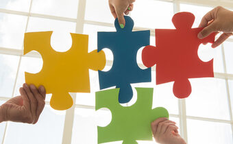 Vier verschiedenfarbige Puzzleteile - symbolisieren Integration