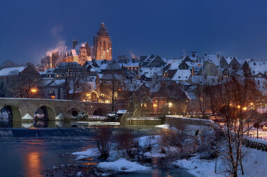 Blick auf die schneebedeckte alte Lahnbrücke und die Altstadt am Abend