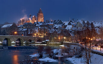 Blick auf die schneebedeckte alte Lahnbrücke und die Altstadt am Abend